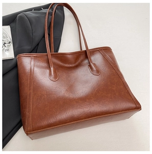 Dettaglio della borsa tote marrone caramello con texture in pelle vintage e cuciture