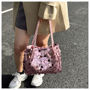 Détail d'un cabas rose à paillettes montrant la texture métallique et les anses tressées