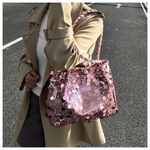Close-up of pink sequin shoulder bag with woven handle and fashion side label