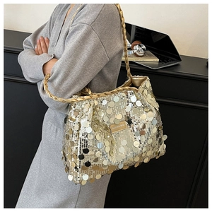 Detailed view of large golden sequins and braided handle on a stylish tote bag