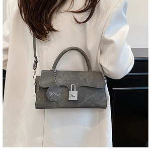 Detail of grey marble texture crossbody bag with silver lock and FASHION tag decoration