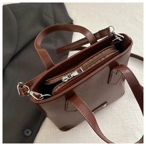 Close-up of metal zipper and interior compartments of brown vintage tote bag