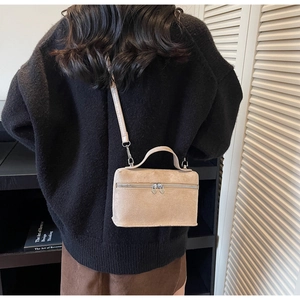 Détail du sac boîte en daim camel clair avec fermeture éclair cœur et bandoulière