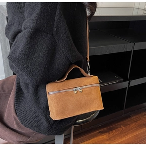 Détail du sac à main en daim avec doubles fermetures éclair uniques en forme de cœur