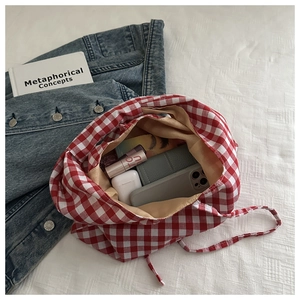 Detail of red and white checkered canvas tote showing spacious interior storage