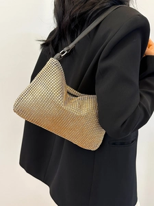 Golden rhinestone mesh shoulder bag with a sleek black leather strap on a model