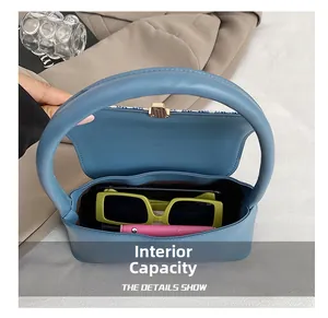Internal capacity of blue leather handbag showing sunglasses and smartphone inside