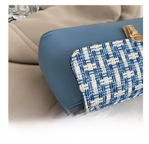 Close-up of blue plaid tweed fabric and golden metal buckle on a premium handbag