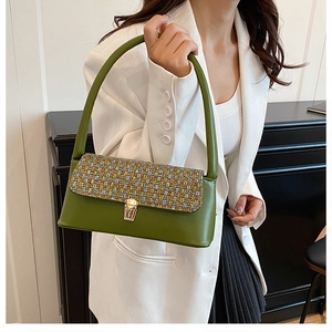 Detail of vintage green leather and tweed patchwork handbag with gold metal clasp