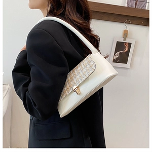 Detail of cream white underarm bag with tweed patchwork flap and gold buckle on model