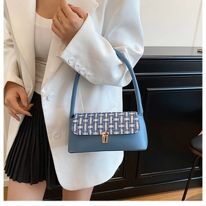 Close-up of blue tweed flap and gold rectangular twist lock on a shoulder bag
