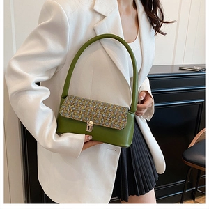 Green baguette bag featuring colorful woven texture and gold square clasp on model