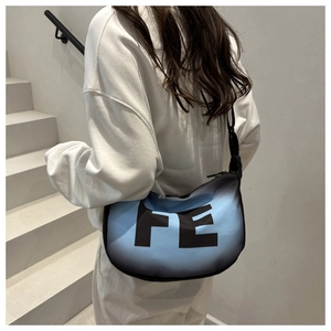 Détail du sac croissant dégradé bleu et noir avec de grandes lettres FE imprimées
