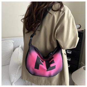 Vue détaillée du sac bandoulière dégradé rose et noir avec logo FE et sangle en nylon