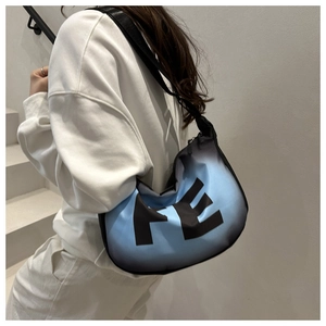 Détail d'un sac à bandoulière dégradé bleu et noir avec imprimé FE sur nylon