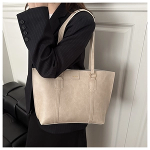 Close-up of the beige tote bag texture and fashion leather tag with metal rings