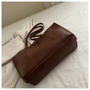 Detail of vintage brown tote bag texture and fashion label on synthetic leather surface