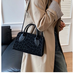 Chic leopard print handbag styled with a khaki trench coat for a modern urban look