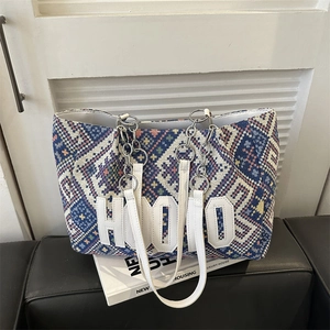 Ethnic woven tote bag with geometric patterns, white logo and metal chain shoulder strap