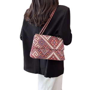 Ethnic bohemian jacquard flap crossbody bag with gold chain strap on model