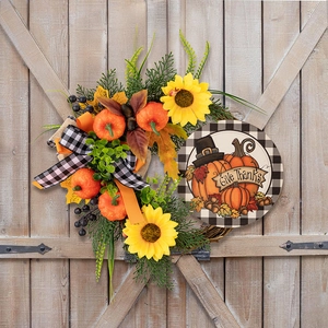 Detail of harvest wreath with sunflowers, pumpkins, and a Give Thanks wood sign on a wooden door