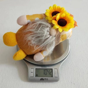 Détail d'un nain d'automne jaune aux tournesols pesant 104,2g sur une balance
