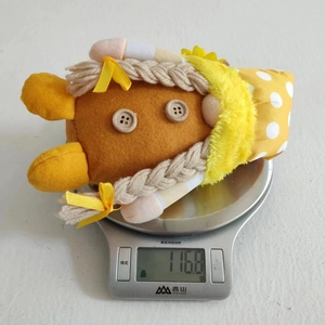 Détail d'un gnome d'automne pesant 116,8g sur une balance de cuisine numérique