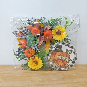 Detail of packaged Thanksgiving pumpkin wreath with sunflower, maple leaves and bow