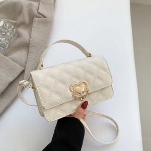 Elegant cream quilted crossbody bag with gold heart clasp and stylish chain detail