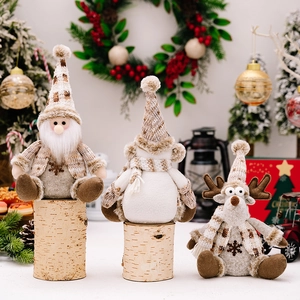 Nordic style Christmas plush figures featuring a gnome, snowman, and reindeer on wood logs