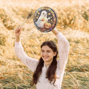 Schamanentrommel mit Halloween-Kürbis-Motiv und Schlägel im Freien von Frau gehalten