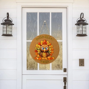 Detail of wooden Thanksgiving turkey sign with Gobble till you Wobble text on front door