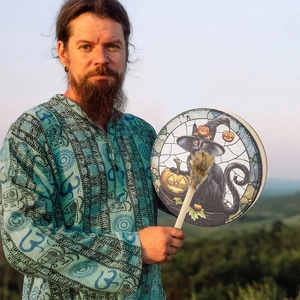 Detailed view of Shaman hand drum with black cat, pumpkin design and soft outdoor lighting