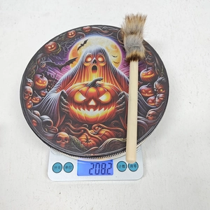 Detailansicht der Halloween-Schamanentrommel mit Kürbis-Motiven auf einer Waage
