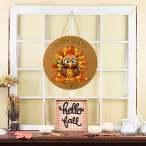 Close-up of a round wooden Thanksgiving turkey sign hanging on a white rustic window frame