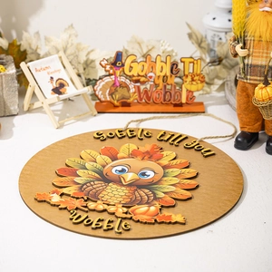 Detail of round Thanksgiving turkey door sign with Gobble till you Wobble text and maple leaves