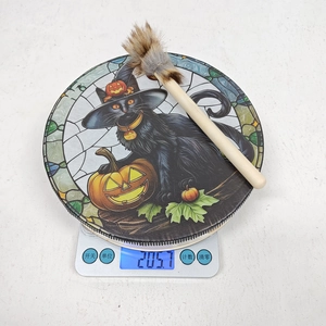 Halloween hand drum with black cat design on a digital scale showing 205.7 grams