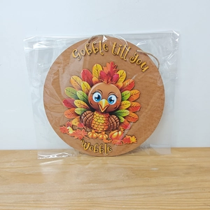 Close-up of wooden Thanksgiving turkey sign with Gobble till you Wobble text and twine rope