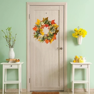 Detailed view of autumn wreath with white pumpkins and maple leaves on a mint green door