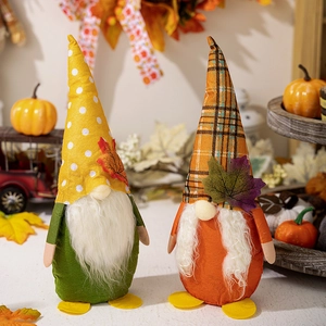Detail of plush Thanksgiving gnomes with maple leaf decor on warm autumn background
