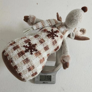 Vista dettagliata di un peluche di renna natalizia pesata su una bilancia digitale a 315g