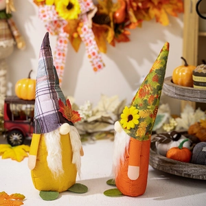 Detail of harvest gnomes with autumn maple leaves and sunflower on warm background
