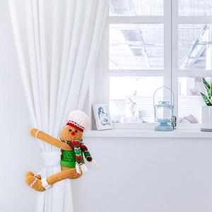 Close-up of a gingerbread man curtain tieback with chef hat and scarf for Christmas decor