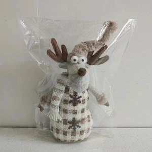 Dettaglio di una renna di Natale in peluche con cappello di maglia e sciarpa a righe