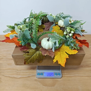 Close-up of Thanksgiving pumpkin wreath on scale showing precise weight of 222.7g