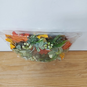 Detailed view of artificial autumn wreath with green pumpkins and maple leaves in packaging