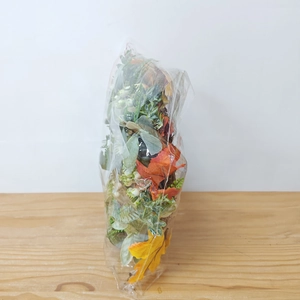 Detail of fall harvest wreath with green leaves and white pumpkins in packaging