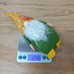 Detail showing a Thanksgiving gnome being weighed on a scale at 234 grams