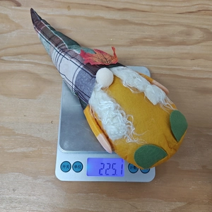 Fall gnome plush weight measurement showing 225.1g on a scale with maple leaf hat detail