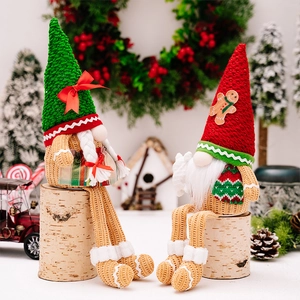 Macro view of Christmas gnome plush dolls with gingerbread hats on birch logs